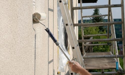 painting walls.Repair and construction concept.Details of painting walls, roller,staircase, scaffolding and other tools for painting walls of the house outside.home renovation outside